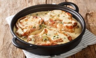 Baked pork chops covered in creamy sauce with herbs.