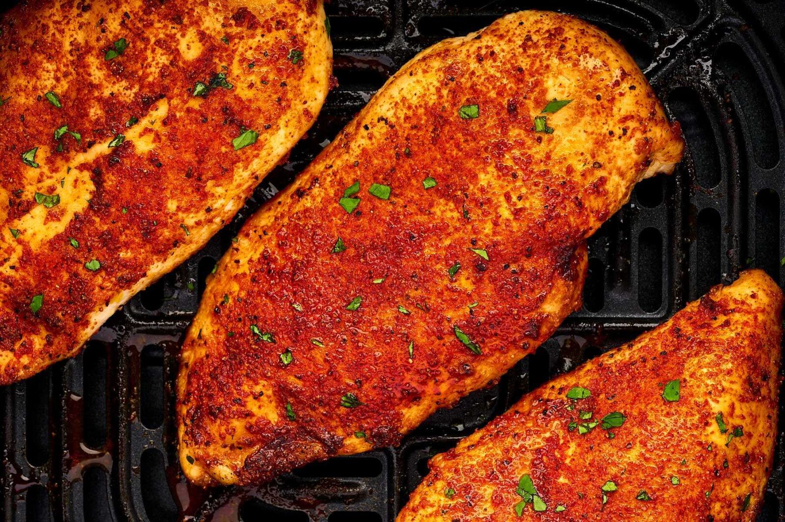 Juicy air fryer chicken breast sliced and served with lemon and fresh herbs