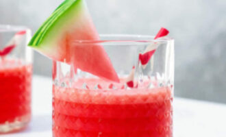 Watermelon vodka cocktail served over ice with fresh watermelon, lime slices, and mint leaves